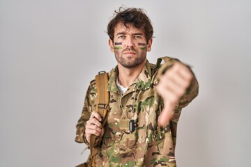 Poster - Hispanic young man wearing camouflage army uniform looking unhappy and angry showing rejection and negative with thumbs down gesture. bad expression.