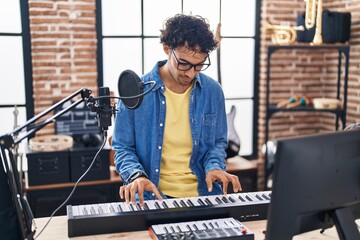 Poster - Young hispanic man musician playing piano keyboard at music studio