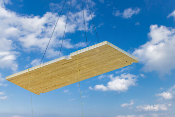 A crane hoisting a pre fabricated laminated floor panel of a mass timber multi story green, sustainable, residential high rise apartment or office building construction project
