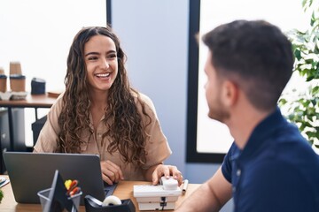 Young hispanic couple business workers using laptop working at office