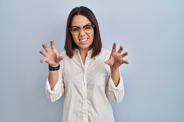 Sticker - Young hispanic woman standing over white background smiling funny doing claw gesture as cat, aggressive and sexy expression