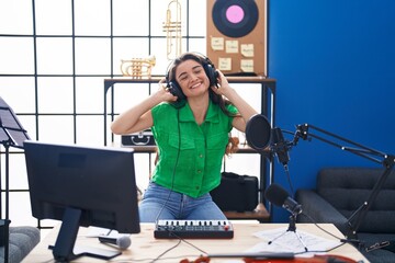 Wall Mural - Young hispanic woman musician having dj session at music studio