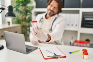 Sticker - Middle age man doctor holding empty test tube at clinic