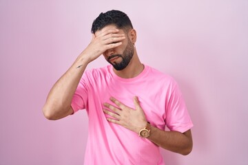 Canvas Print - Hispanic young man standing over pink background touching forehead for illness and fever, flu and cold, virus sick