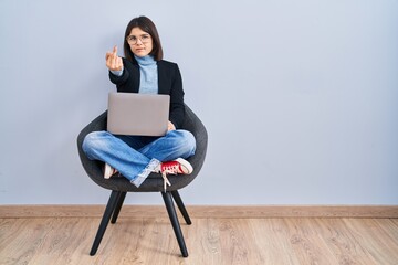 Sticker - Young hispanic woman sitting on chair using computer laptop showing middle finger, impolite and rude fuck off expression