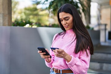 Wall Mural - Young hispanic woman smiling confident standing at street