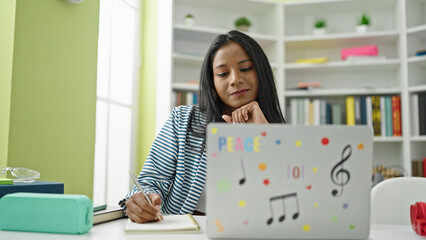 Wall Mural - African american woman student using laptop writing notes at library university