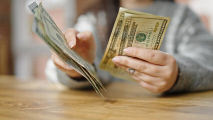 Hands of woman counting dollars at room