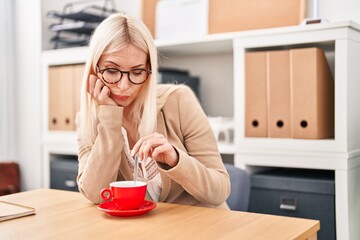 Canvas Print - Young blonde woman business worker tired drinking coffee at office