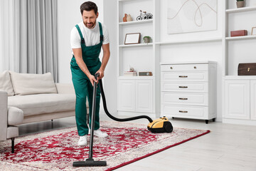 Canvas Print - Dry cleaner's employee hoovering carpet with vacuum cleaner in room