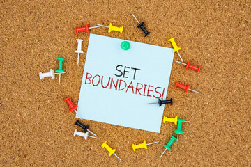 Poster - Set boundaries text on light blue post-it paper pinned on bulletin cork board surrounding by multi color pins. This message can be used in business concept about setting boundaries.