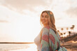 © Daniel - Portrait of one happy beautiful woman on the sand of the beach enjoying and having fun at the sunset of the day. Looking at the camera smiling..