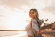 © Daniel - Portrait of one happy beautiful woman on the sand of the beach enjoying and having fun at the sunset of the day. Looking at the camera smiling..