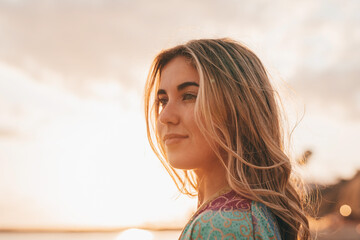 Portrait of one young woman at the beach looking at the sea enjoying free time and freedom outdoors. Having fun relaxing and living happy moments..