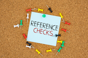 Poster - Reference checks text on light blue post-it paper pinned on bulletin cork board surrounding by multi color pins. This message can be used in business concept about reference checks.