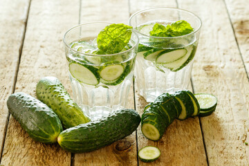 Detox water with cucumber on wooden table