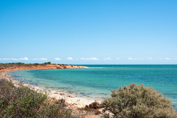 Wall Mural - view of the sea from the beach, red orange sand and turquoise water. Shark bay Australia