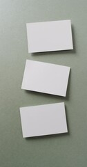 Canvas Print - Vertical video of blank white business cards on green background, copy space, slow motion