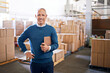 © Y.A./peopleimages.com - Checklist, happy and portrait of man in warehouse for cargo, storage and shipping. Distribution, ecommerce and logistics with employee in factory plant for supply chain, package or wholesale supplier