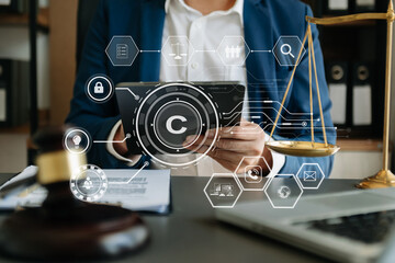 Wall Mural - Copyright or patent concept, Person hand using laptop computer, tablet and smartphone with virtual screen copyright icon trademark, Creation ownership against piracy. at office.