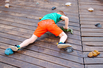 a boy on a wooden climbing wall