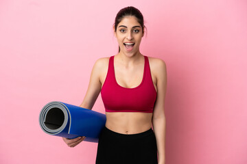 Wall Mural - Young sport caucasian woman going to yoga classes while holding a mat with surprise facial expression