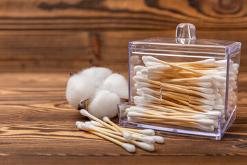 Sticker - White cotton swabs on a brown wood background. Cotton buds. Bamboo cotton buds. Eco-friendly. Hygienic cotton swabs for ears. Place for text. Place to copy.