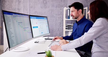 Poster - Employee Working On Calendar Schedule