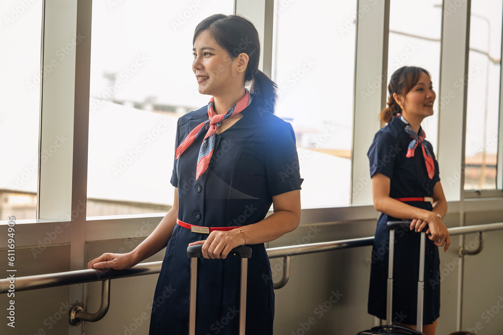 Female flight attendants wearing uniforms stand smiling happily ...
