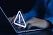 © ภัทรชัย รัตนชัยวงค์ - Businessman or employee with warning triangle sign for warning error Hack Alert System Warning cyber attack