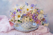 Bouquet of spring and summer flowers in a cup on the table,  aquilegia, spirea, anemone, forget me not flowers, pansies, violet, beautiful postcard, still life, blur.