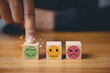 © sorapop - Positive customer experience feedback with a businessman's hand selecting a smiley face on a wooden cube. Satisfaction survey and feedback concept. 5-star satisfaction is guaranteed.