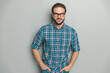 © Viorel Sima - portrait of serious young man wearing eyeglasses and holding hands in pockets