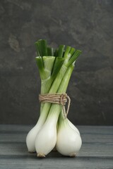 Bunch of green spring onions on grey wooden table