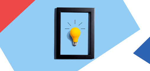 Wall Mural - Yellow light bulb inside a frame - inspiration, creativity, energy, electricity themes