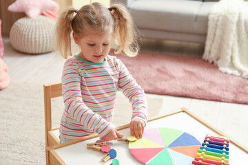 Sticker - Cute little girl playing matching game with clothespins at home