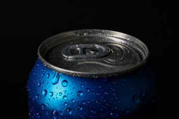 Blue can of fresh soda with water drops on dark background, closeup