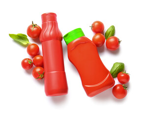 Bottles of ketchup and tomatoes on white background