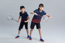 Cheerful Girl And Boy Playing Badminton