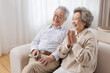 © Blue Jean Images - Cheerful senior couple watching TV at home