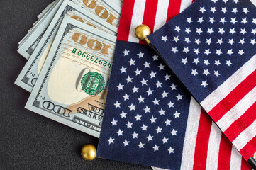 American flags with dollar bills on black background.