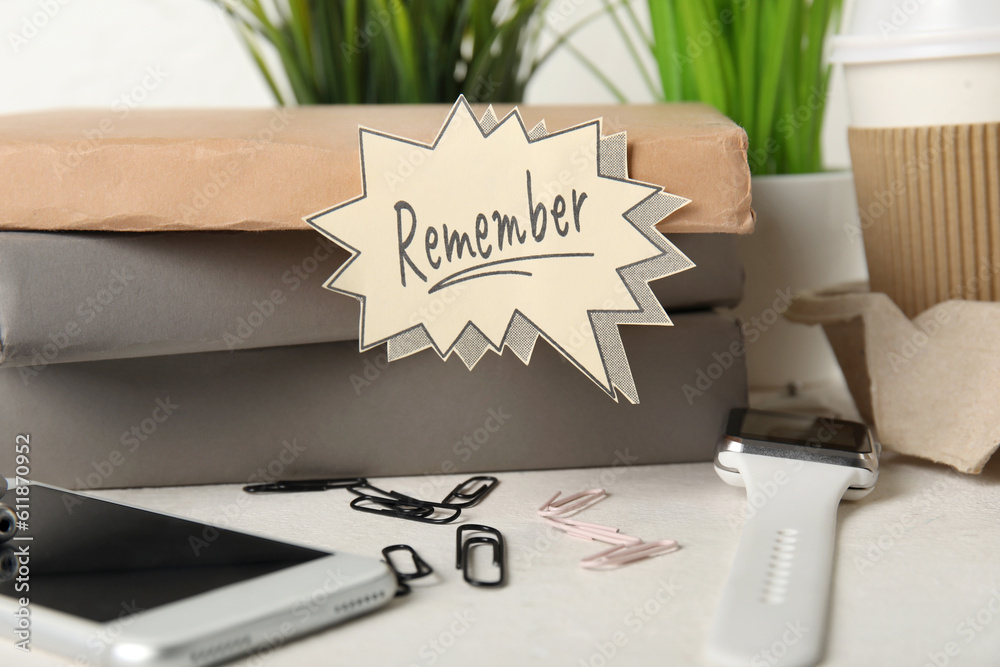 Books with reminder, devices and cup of coffee on white table