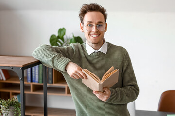 Wall Mural - Young man reading book in library