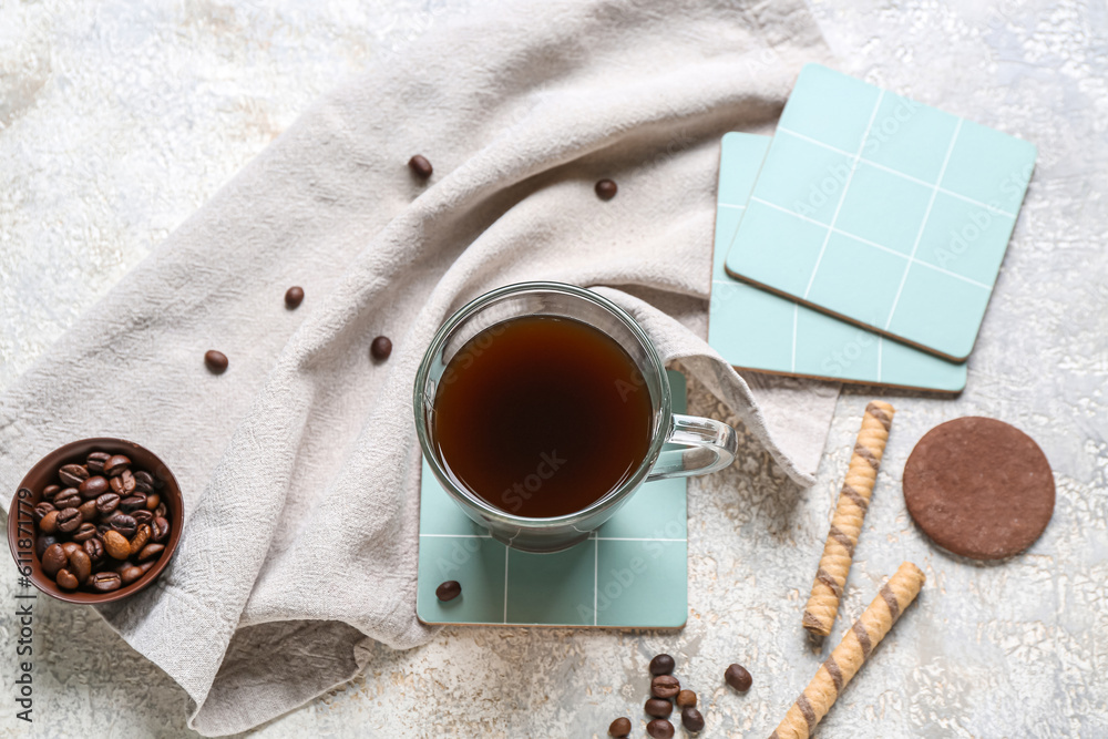 Drink coasters with cup of coffee and sweets on grey grunge table