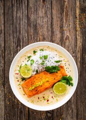 Wall Mural - Creamy coconut lime salmon with rice noodles on wooden table
