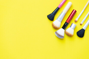 Wall Mural - Set of cosmetics brushes on yellow background