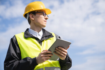 Poster - Engineer with digital tablet on a background of blue sky	