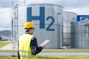 Sticker - Engineer with tablet computer on a background of Hydrogen factory.