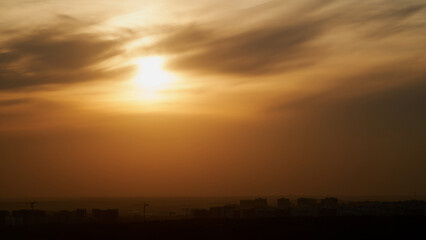 Wall Mural - Sunset sky with red light of the setting sun. Evening clouds in the orange light of sunset rays