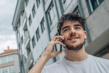 Wall Mural - young man on the street talking on mobile phone or smartphone